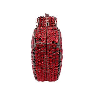 Side view of heart-shaped red evening clutch featuring sparkling red crystals and metal frame