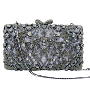 Detailed macro view of silver rhinestone evening clutch bag with geometric patterns and chain