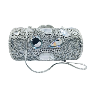 Close-up of silver cylinder clutch with hollow metal details and large sparkling diamonds