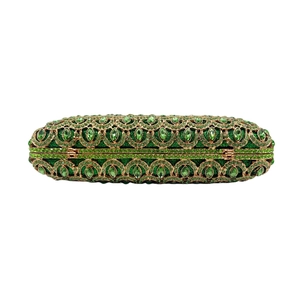 Detail showing the emerald green rhinestones and golden hollow pattern on the evening clutch