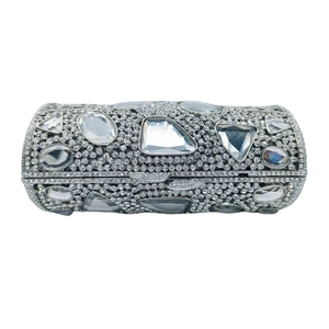 Macro shot of silver cylindrical clutch featuring full diamond pavé and crystal accents