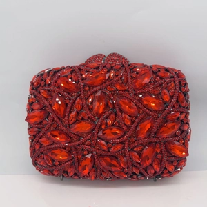 Close-up of vibrant red crystal evening clutch bag with detailed metal leaf clasp