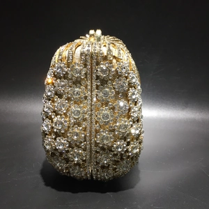 Detailed close-up of a gold metal hollow evening clutch with full handset rhinestones