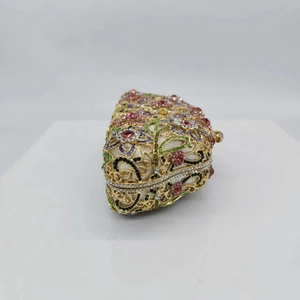 Detailed side view of a floral crystal evening clutch with colorful rhinestones on gold frame