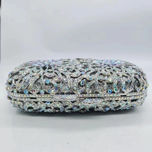 Detailed macro of silver hollow metal floral design with colorful rhinestones on party purse