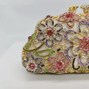 Close-up of luxury floral晚宴包 featuring intricate multi-color rhinestone inlay and golden filigree