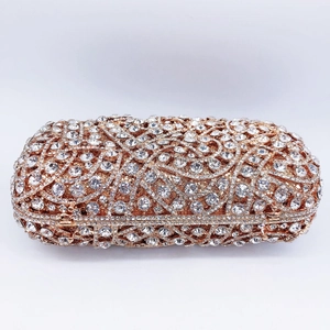 Detailed close-up of luxury evening bag featuring floral crystal relief on gold metal frame