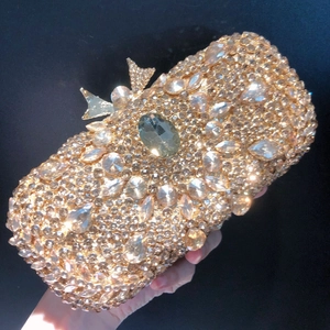 Macro detail of gold evening clutch featuring dense rhinestones and bow clasp