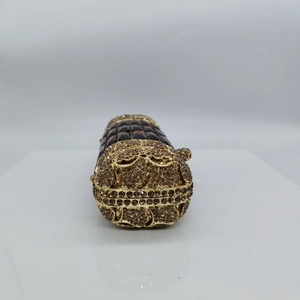 Dettaglio pochette di lusso con strass gialli, incisioni vintage e gemme incastonate