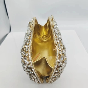 Inside view of a gold evening clutch bag with sparkling rhinestones and satin lining