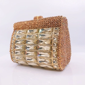 Macro view of crystal rhinestones and rectangular gemstones on champagne evening clutch