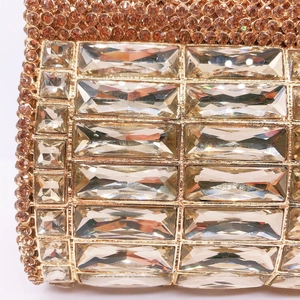 Detalle macro de bolso de noche oro champán con pedrería de cristal de corte esmeralda