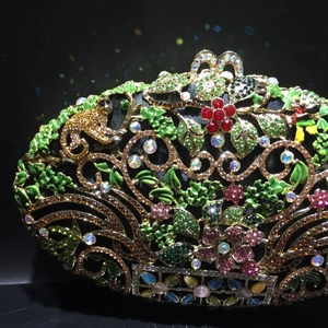 Detailed close-up of a luxury floral evening clutch with colorful rhinestones and gold monkey