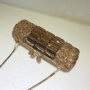 Dettaglio della pochette dorata con grandi cristalli marroni e strass scintillanti