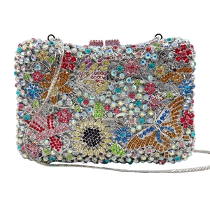 Detailed macro view of colorful crystal butterfly and floral patterns on silver clutch