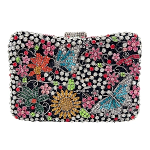 Macro detail of intricate floral and butterfly patterns with colorful rhinestones on crystal clutch