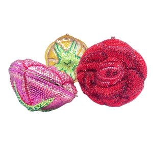 Close-up of luxury flower-shaped evening bags with shimmering crystals in red pink and yellow