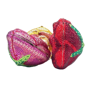 Close-up of three luxury rose-shaped crystal evening bags in red, pink, and gold finish
