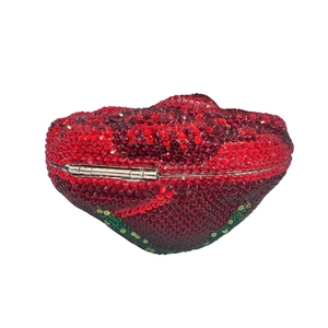 Detailed close-up of a rose-shaped evening clutch bag with red crystal floral embellishment