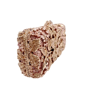 Detail of luxury evening clutch featuring rose gold floral cutouts and sparkling rhinestones