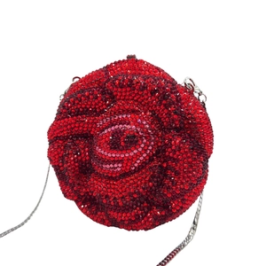 Close-up of red rose-shaped evening bag with crystal rhinestones and silver chain