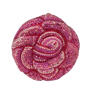 Macro detail of rose-shaped evening bag with gradient pink and red crystal petals