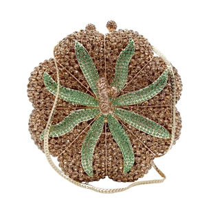 Dettaglio della borsa da sera a fiore color oro champagne con foglie in strass verdi