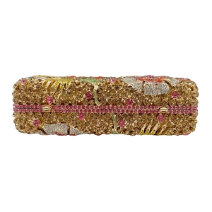 Detailed macro of floral pattern stone clutch with colorful crystals on metal hard case