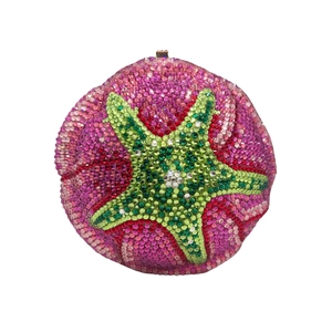 Macro detail of star-shaped crystal pattern on luxury round evening clutch bag