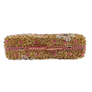 Detailed close-up of champagne gold and pink rhinestones on a luxury stone clutch bag