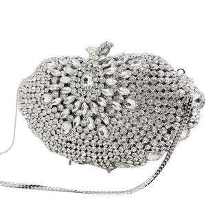 Détail de pochette de soirée luxueuse en strass argentés avec cristaux et chaîne en métal