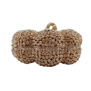 Dettaglio macro della borsa a zucca con strass dorati e chiusura ad anello metallico