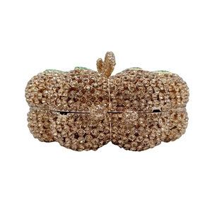 Dettaglio di una pochette da sera a forma di zucca con strass color champagne dorato