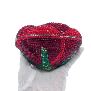 Detailed view of handmade crystal evening clutch featuring red and green floral rhinestone pattern