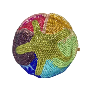 Macro detail of the colorful crystal encrusted gradient star pattern on the sphere clutch