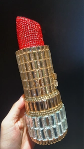 Detailed view of luxury lipstick-shaped evening bag with sparkling rhinestones and crystals