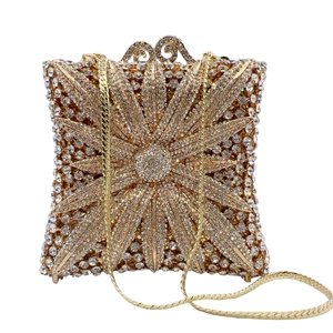 Macro detail of champagne gold evening bag featuring radiant rhinestone flower patterns