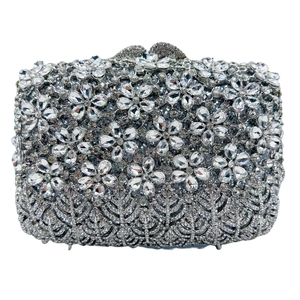 Macro detail of silver evening clutch bag featuring intricate crystal floral patterns