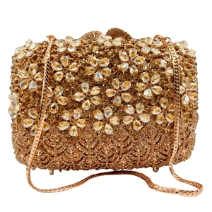 Detail of gold evening clutch bag with crystal floral patterns and base protective studs
