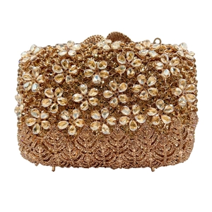 Detail of evening clutch bag showing intricate crystal flower patterns and golden rhinestones