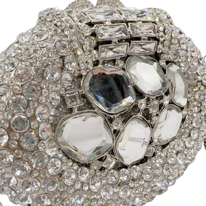 Close-up of silver evening clutch bag with intricate crystal inlay and metal clasp