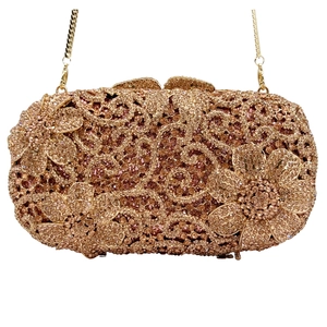 Détail macro d'une pochette de soirée or rose avec motifs floraux en cristal
