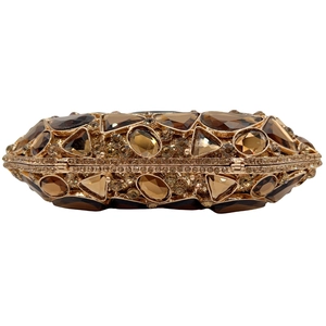 Macro detail of luxury gold evening bag with champagne and amber crystals inlay