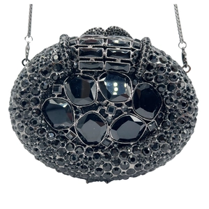 Close-up of black evening bag featuring hollow metal design and large faceted crystals