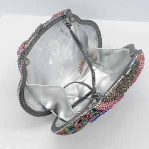 Abendhandtasche in Muschelform mit bunten Strasssteinen und Metallkettenriemen