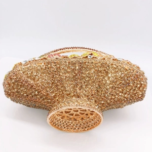 Macro detail of golden rhinestone basket clutch with intricate hollow metal base
