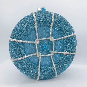 Close-up of circular sky blue evening clutch with rhinestones and sapphire center