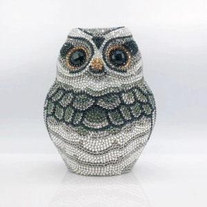 Macro shot of owl clutch bag with intricate silver and black rhinestones and gemstone eyes