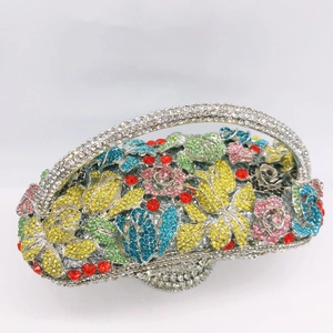 Detailed macro view of multicolor crystals and floral rhinestone patterns on the clutch bag