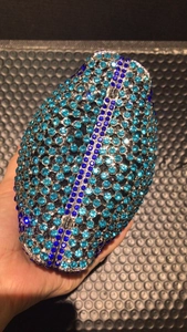 Close-up of a sparkling blue rhinestone football evening bag with silver metal trim
